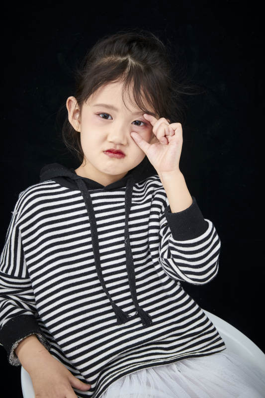黑色背景的调皮可爱的亚洲小女孩儿童图片