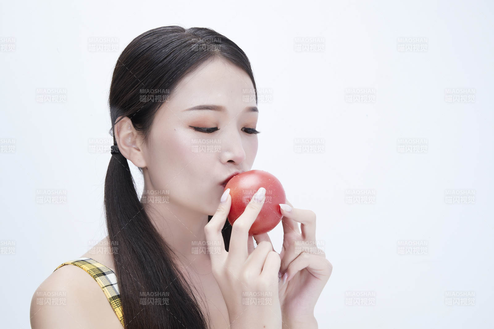 啃咬番茄身穿格子吊带裙的亚洲可爱少女人像图片