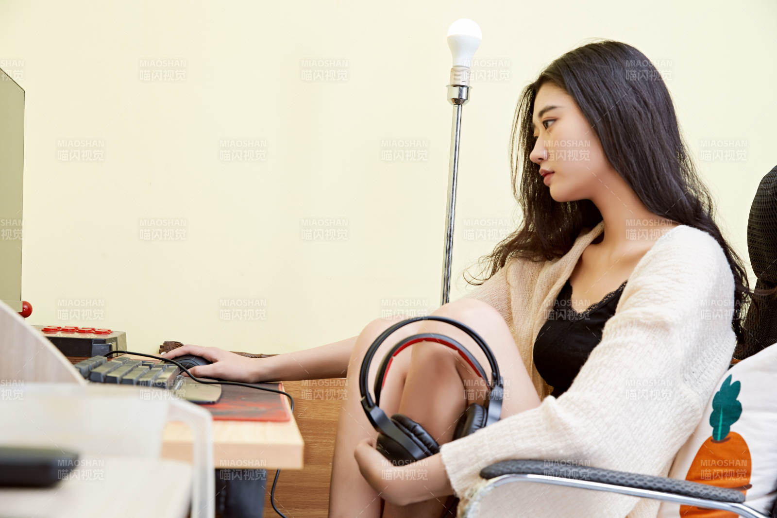 在家里坐在椅子上打游戏的美丽女孩图片