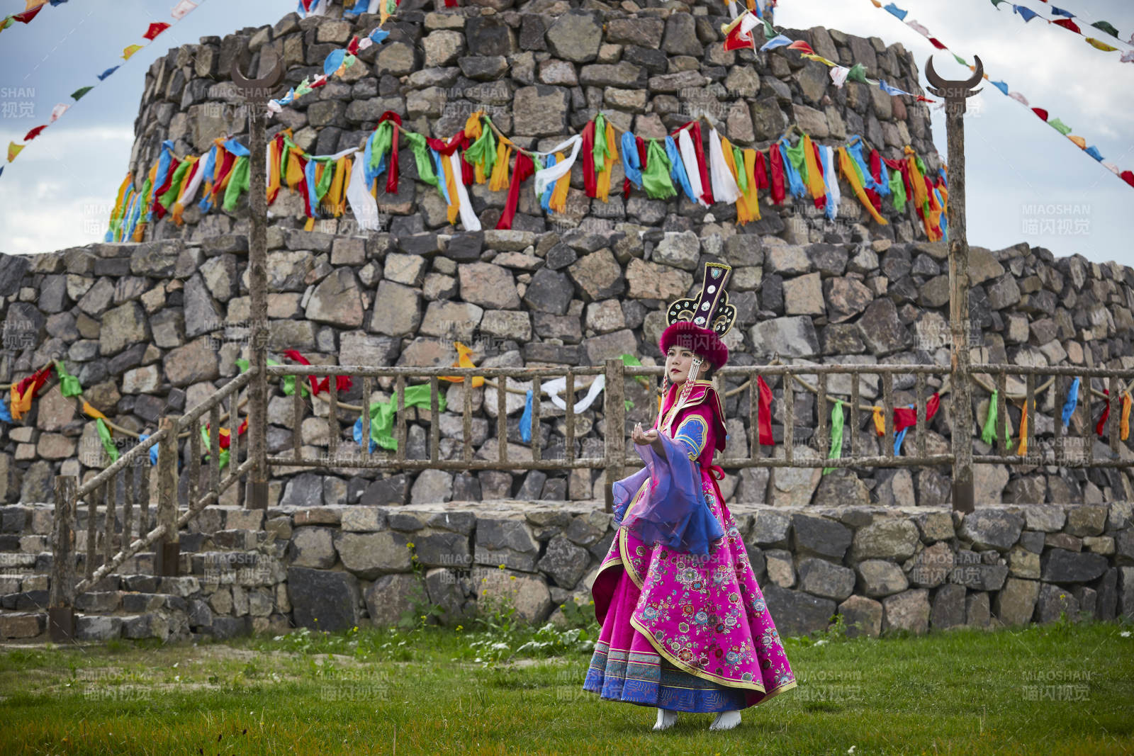 草原上敖包前身穿豪华蒙古族服饰的蒙族少女图片