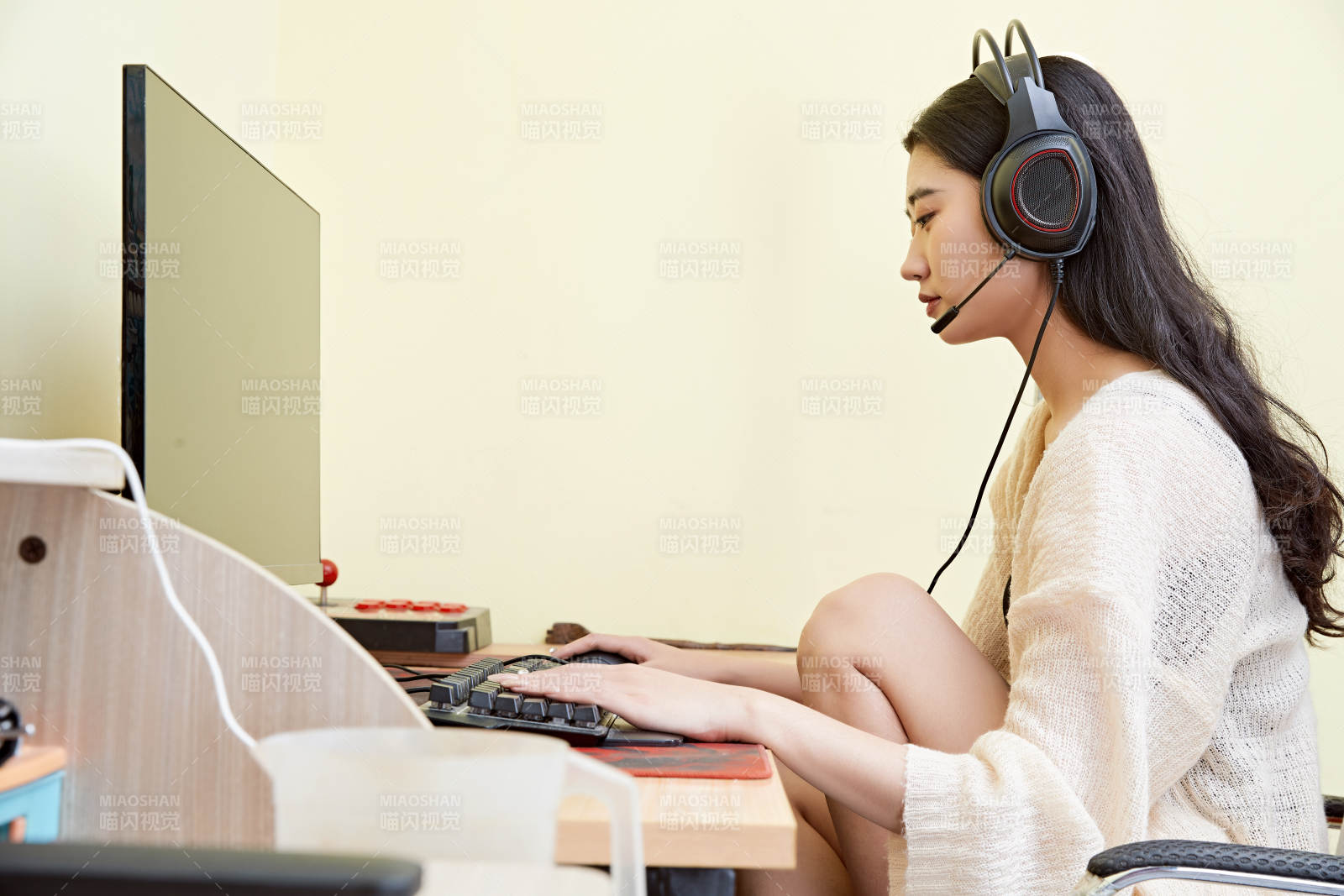 在家里坐在椅子上打游戏的美丽女孩图片