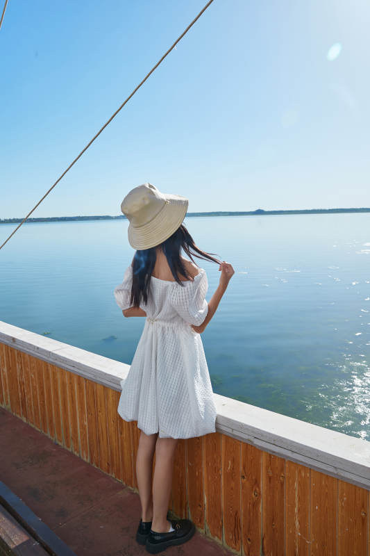 在湖畔木制帆船上的亚洲美女图片