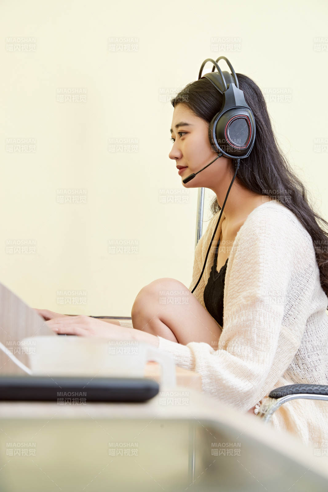 在家里坐在椅子上打游戏的美丽女孩图片