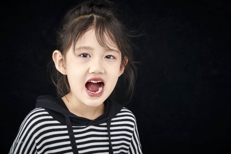 黑色背景的调皮可爱的亚洲小女孩儿童图片