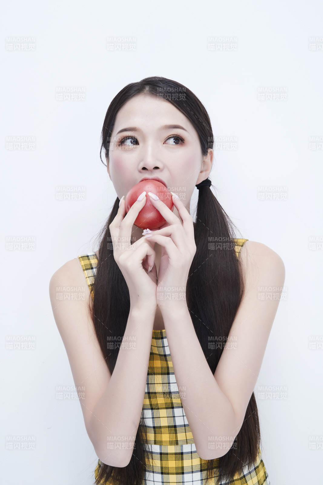 啃咬番茄身穿格子吊带裙的亚洲可爱少女人像图片