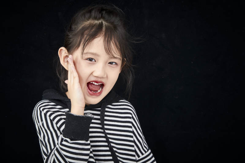 黑色背景的调皮可爱的亚洲小女孩儿童图片