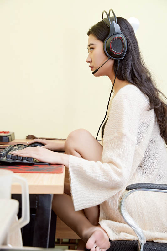 在家里坐在椅子上打游戏的美丽女孩图片