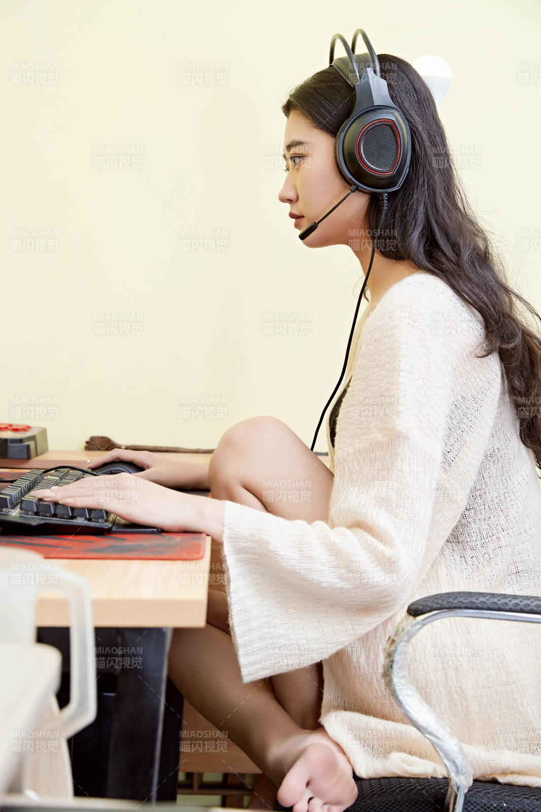 在家里坐在椅子上打游戏的美丽女孩图片