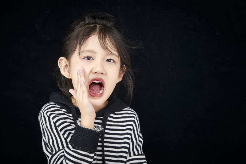 黑色背景的调皮可爱的亚洲小女孩儿童图片