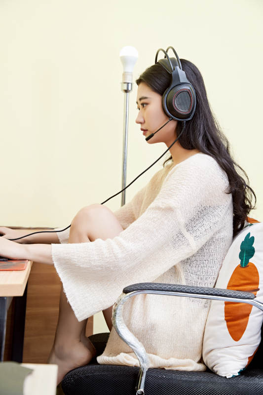 在家里坐在椅子上打游戏的美丽女孩图片