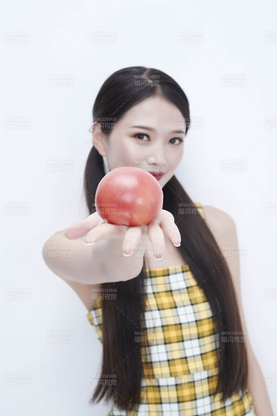 啃咬番茄身穿格子吊带裙的亚洲可爱少女人像图片