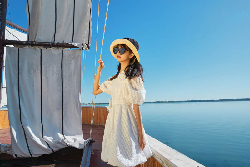 在湖畔木制帆船上的亚洲美女图片