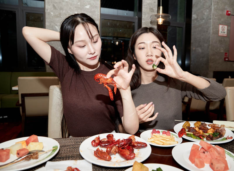 在酒店自助餐厅大吃特吃的亚洲可爱闺蜜少女图片