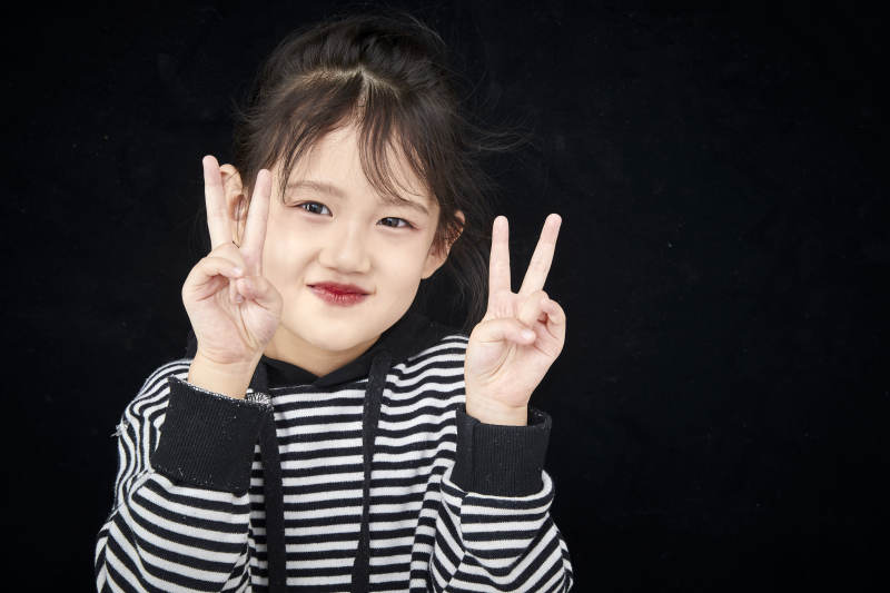 黑色背景的调皮可爱的亚洲小女孩儿童图片