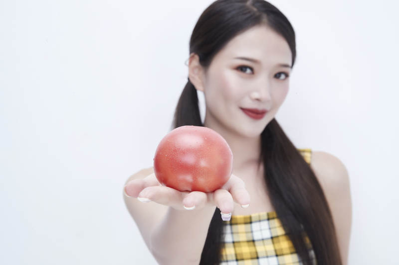 啃咬番茄身穿格子吊带裙的亚洲可爱少女人像图片