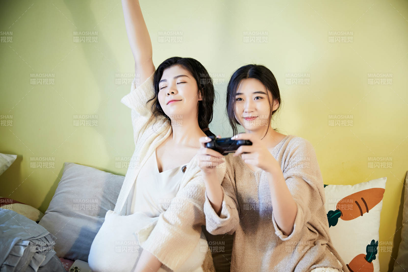 坐在床上打电玩的俩位美女图片