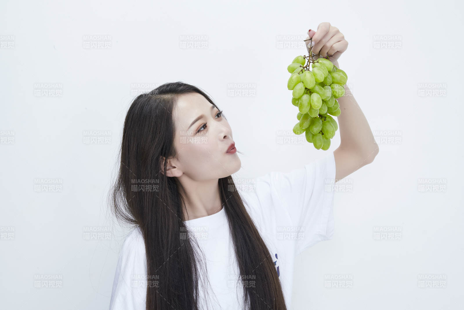 吃葡萄的穿白色长T血衫的长发可爱少女人像图片