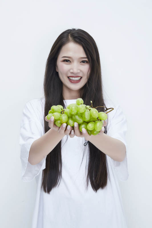 吃葡萄的穿白色长T血衫的长发可爱少女人像图片