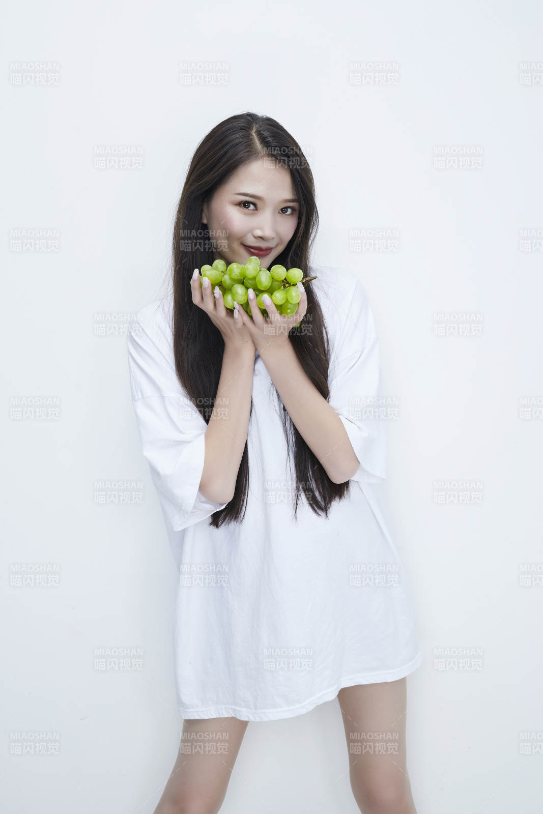 吃葡萄的穿白色长T血衫的长发可爱少女人像图片