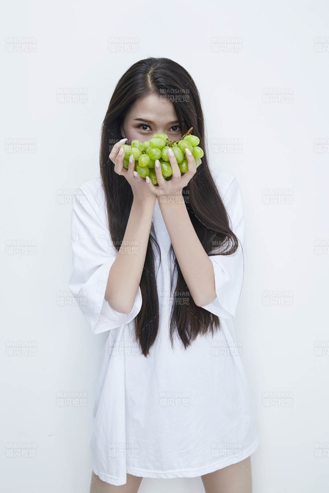 吃葡萄的穿白色长T血衫的长发可爱少女人像图片