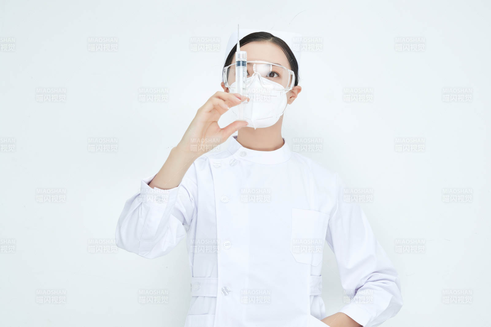 穿护士服戴口罩手执针筒的年轻女护士图片