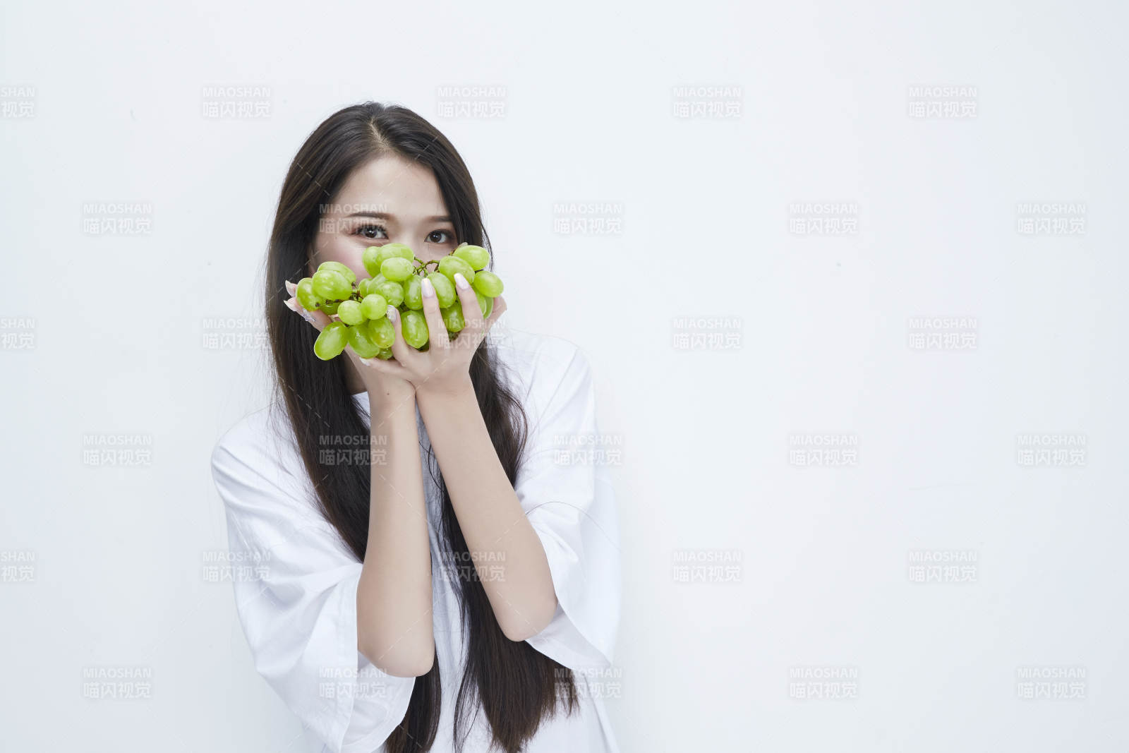 吃葡萄的穿白色长T血衫的长发可爱少女人像图片