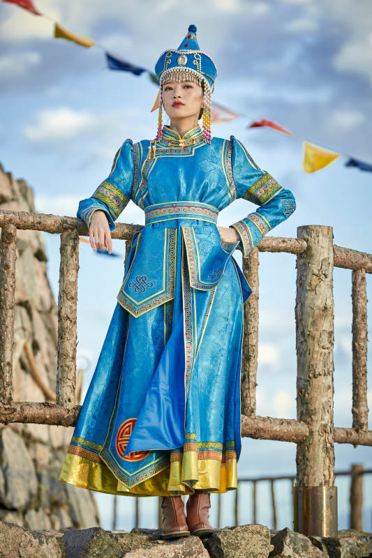 草原上敖包前身穿豪华蒙古族服饰的蒙族少女图片