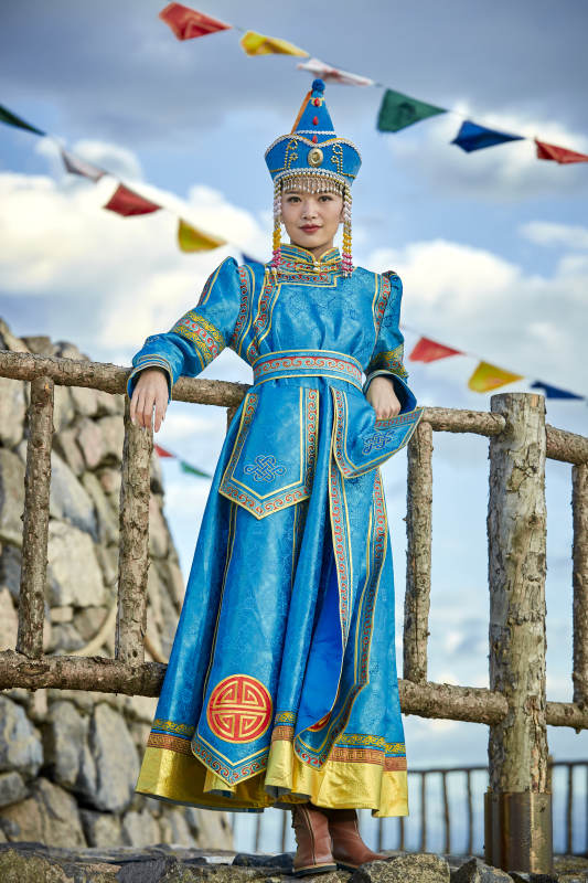 草原上敖包前身穿豪华蒙古族服饰的蒙族少女图片