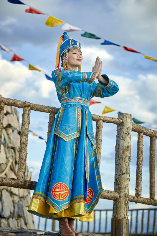 草原上敖包前身穿豪华蒙古族服饰的蒙族少女图片