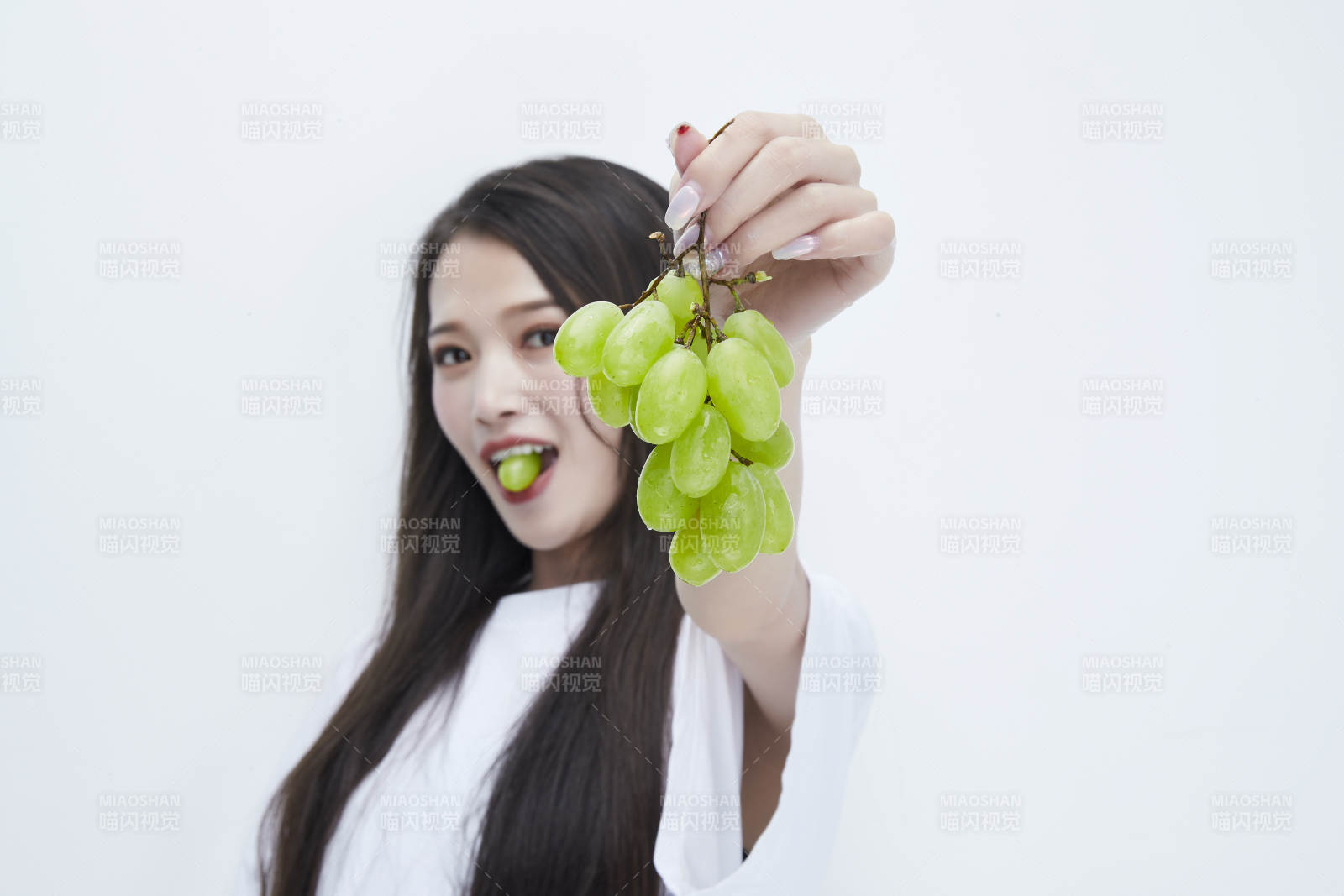 吃葡萄的穿白色长T血衫的长发可爱少女人像图片