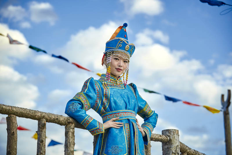 草原上敖包前身穿豪华蒙古族服饰的蒙族少女图片