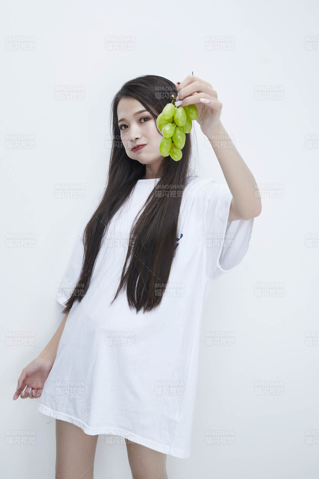 吃葡萄的穿白色长T血衫的长发可爱少女人像图片