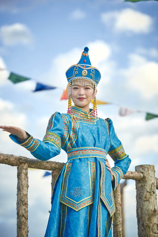 草原上敖包前身穿豪华蒙古族服饰的蒙族少女图片