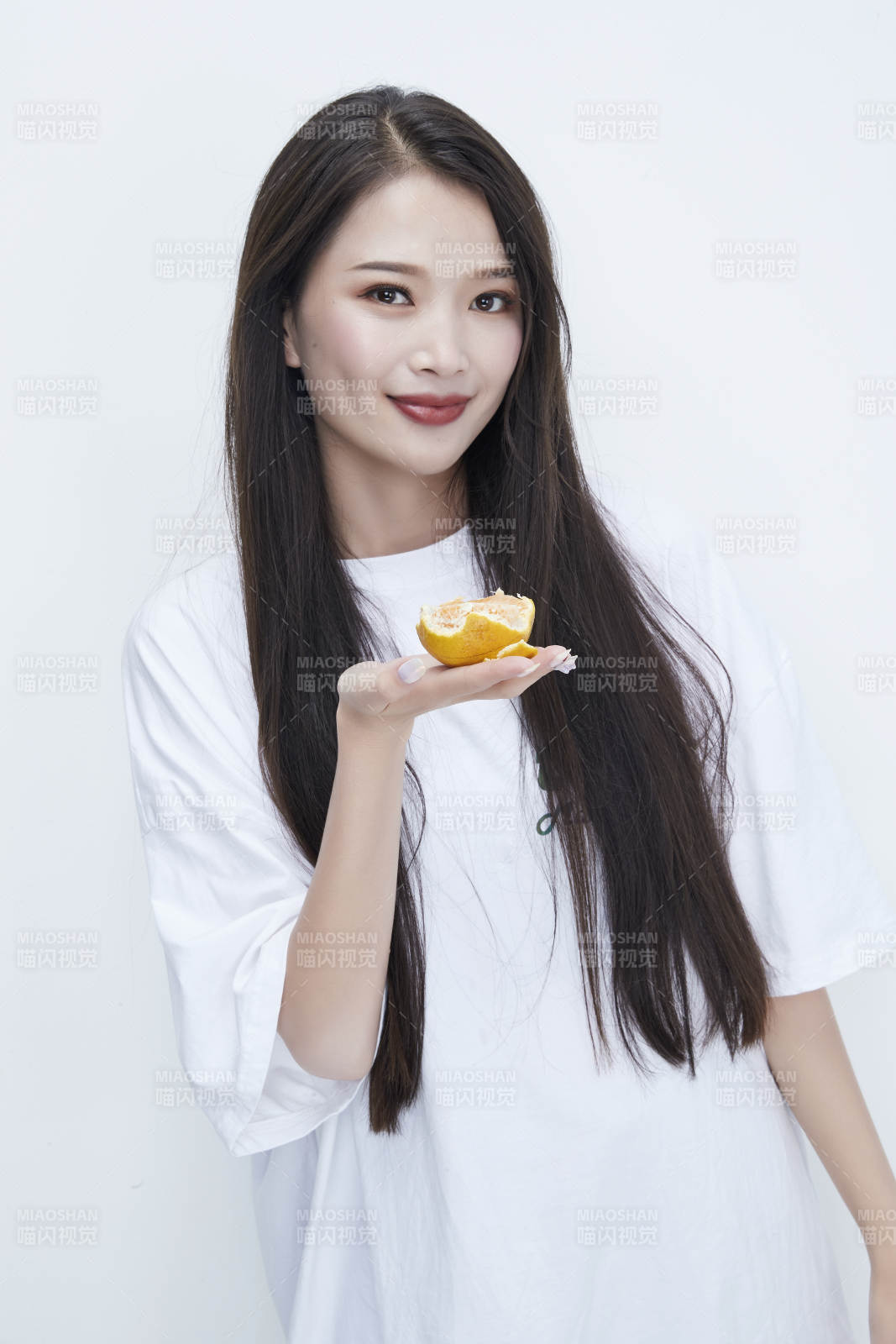 拿着拨开的橙子穿白色长T血的可爱少女人像图片