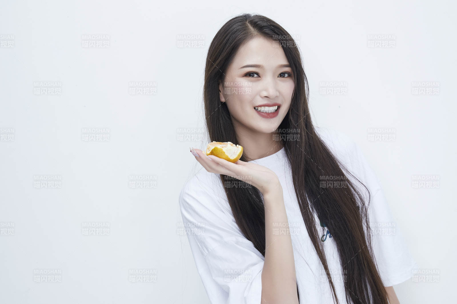 拿着拨开的橙子穿白色长T血的可爱少女人像图片