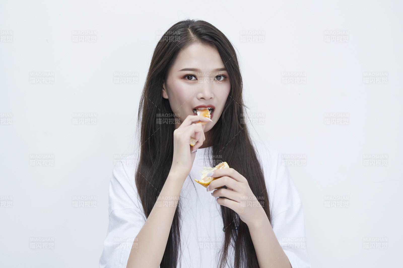 拿着拨开的橙子穿白色长T血的可爱少女人像图片