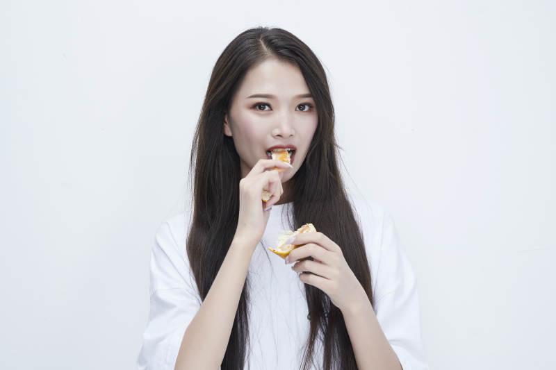 拿着拨开的橙子穿白色长T血的可爱少女人像图片