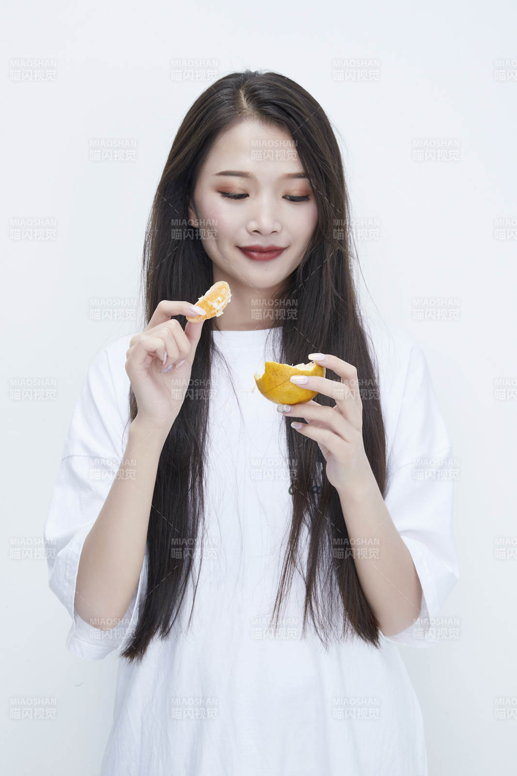 拿着拨开的橙子穿白色长T血的可爱少女人像图片