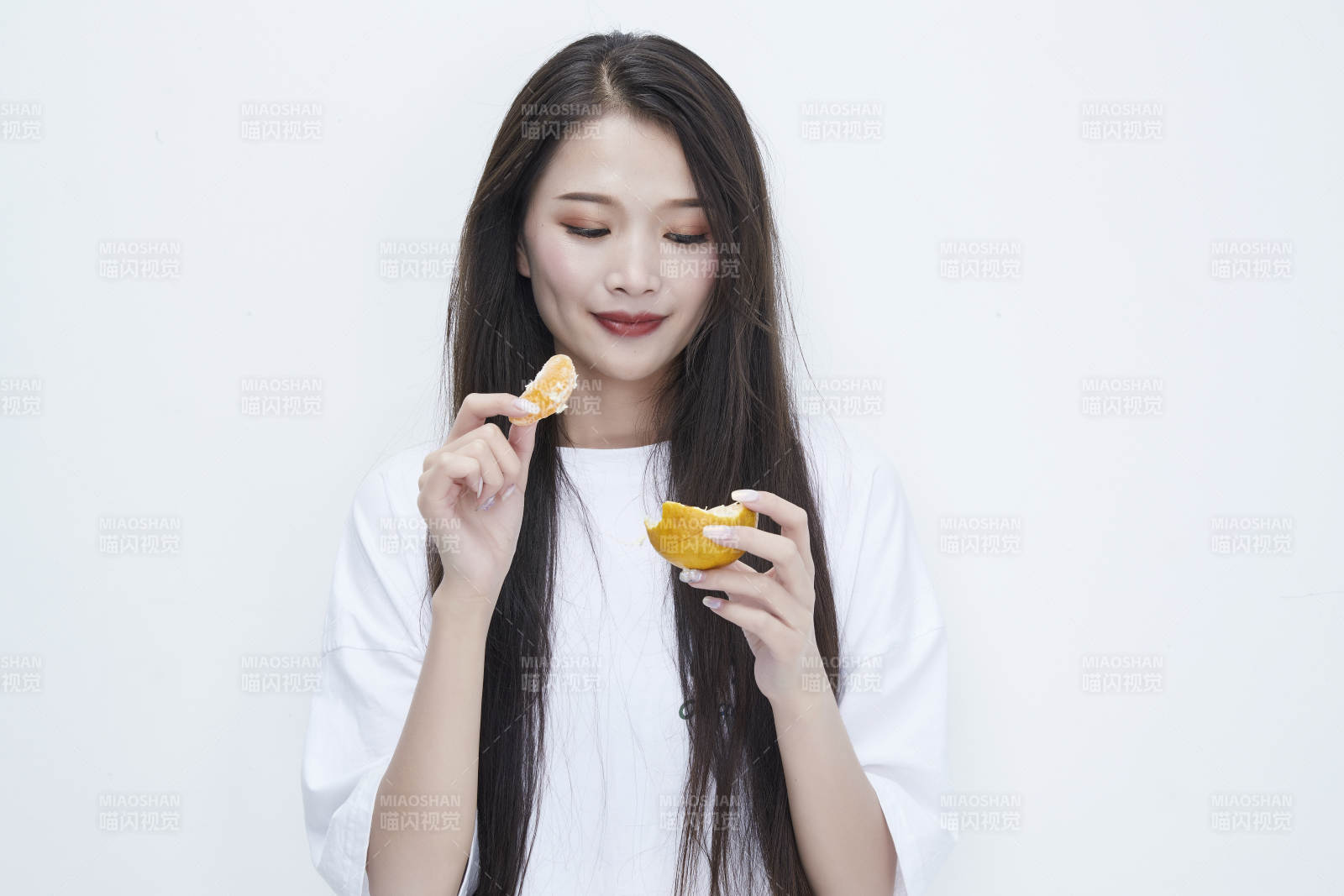 拿着拨开的橙子穿白色长T血的可爱少女人像图片