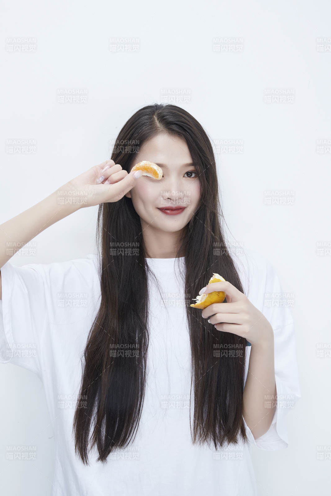 拿着拨开的橙子穿白色长T血的可爱少女人像图片