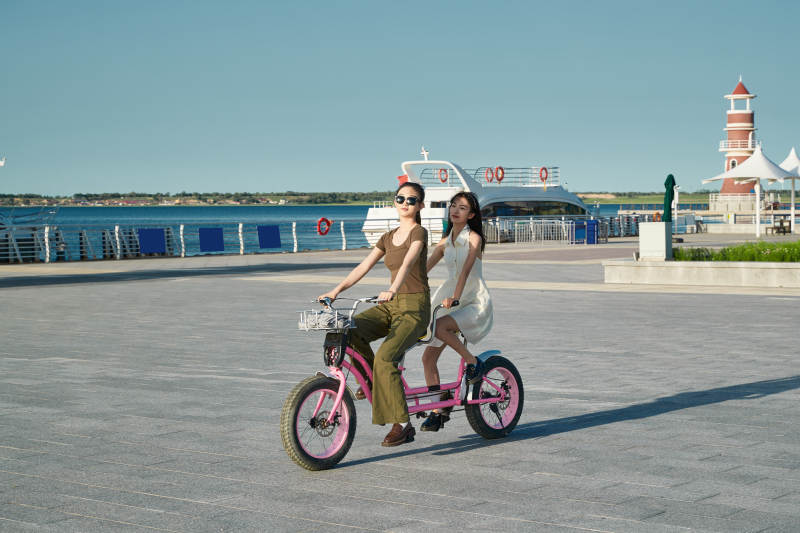 夕阳下湖边码头骑双人脚踏车的闺蜜少女图片