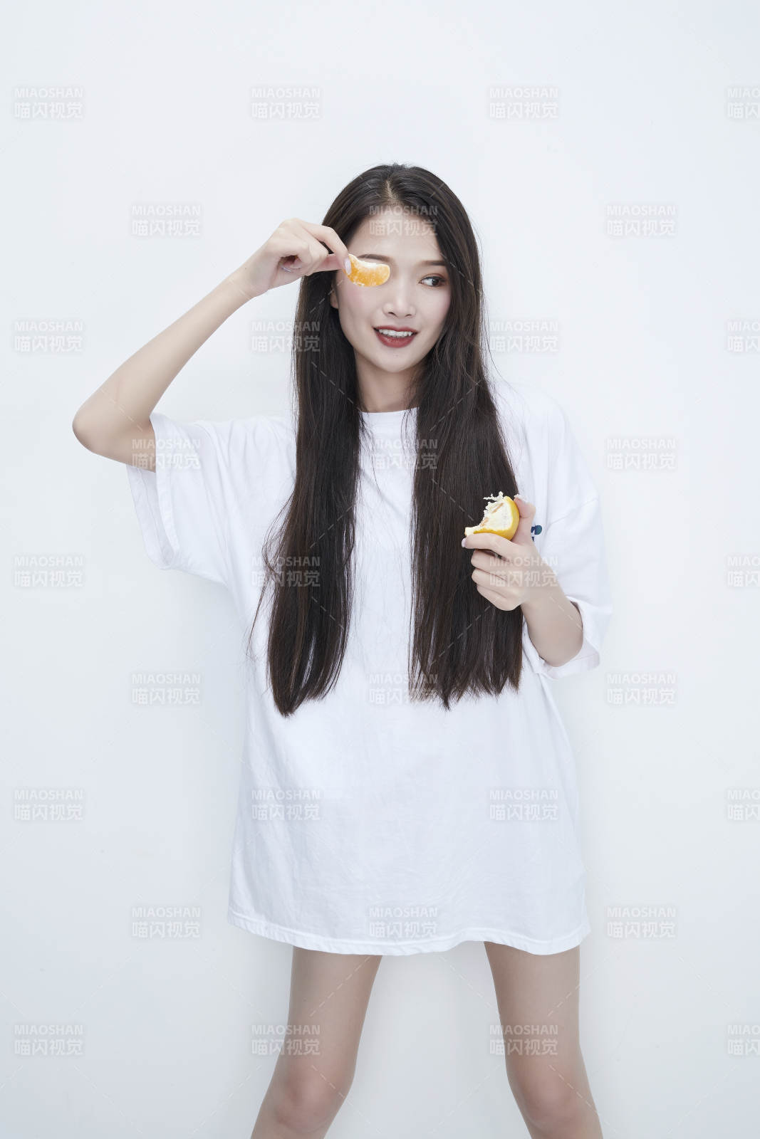 拿着拨开的橙子穿白色长T血的可爱少女人像图片