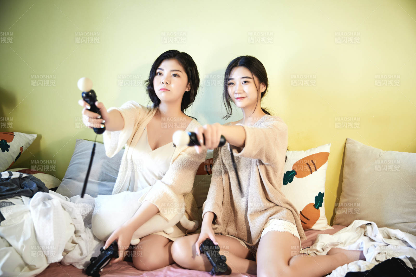 坐在床上打电玩的俩位美女图片