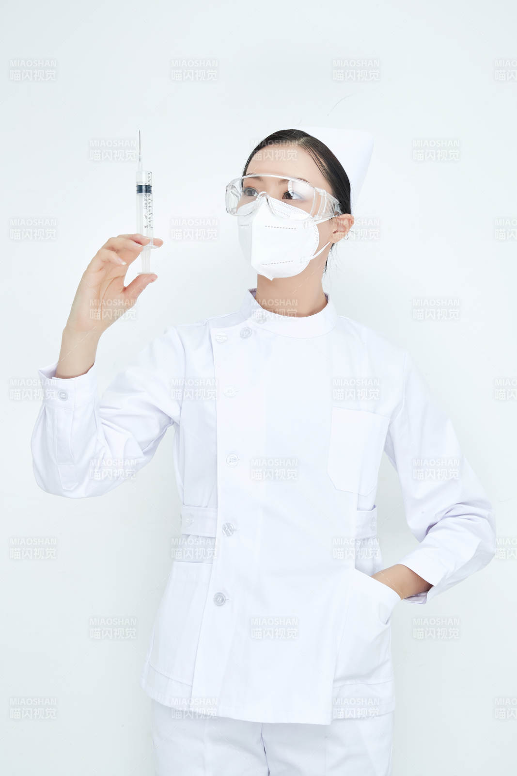 穿护士服戴口罩手执针筒的年轻女护士图片