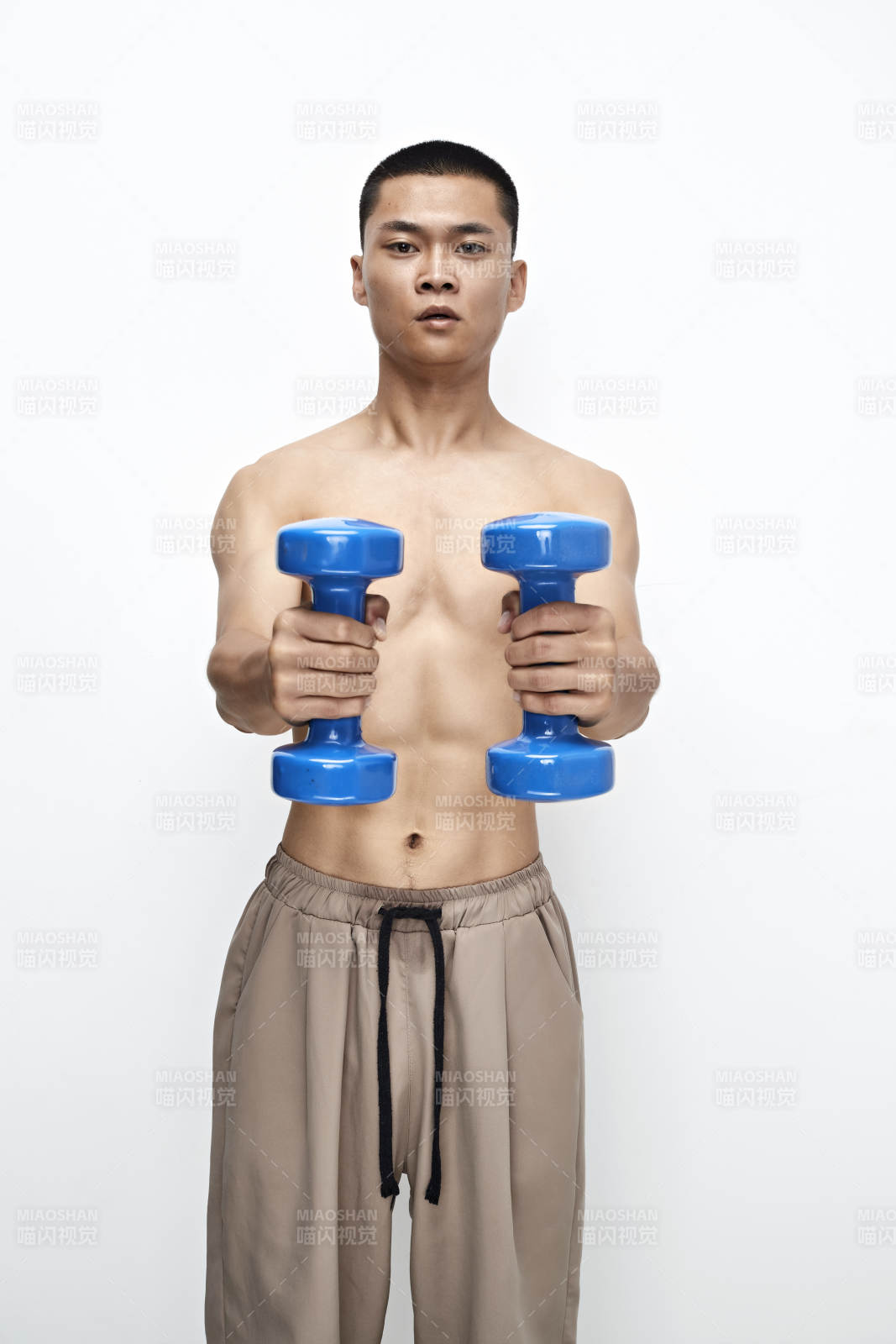 使用哑铃进行健身锻炼的亚洲男性图片