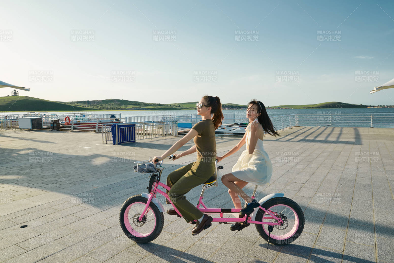 夕阳下湖边码头骑双人脚踏车的闺蜜少女图片