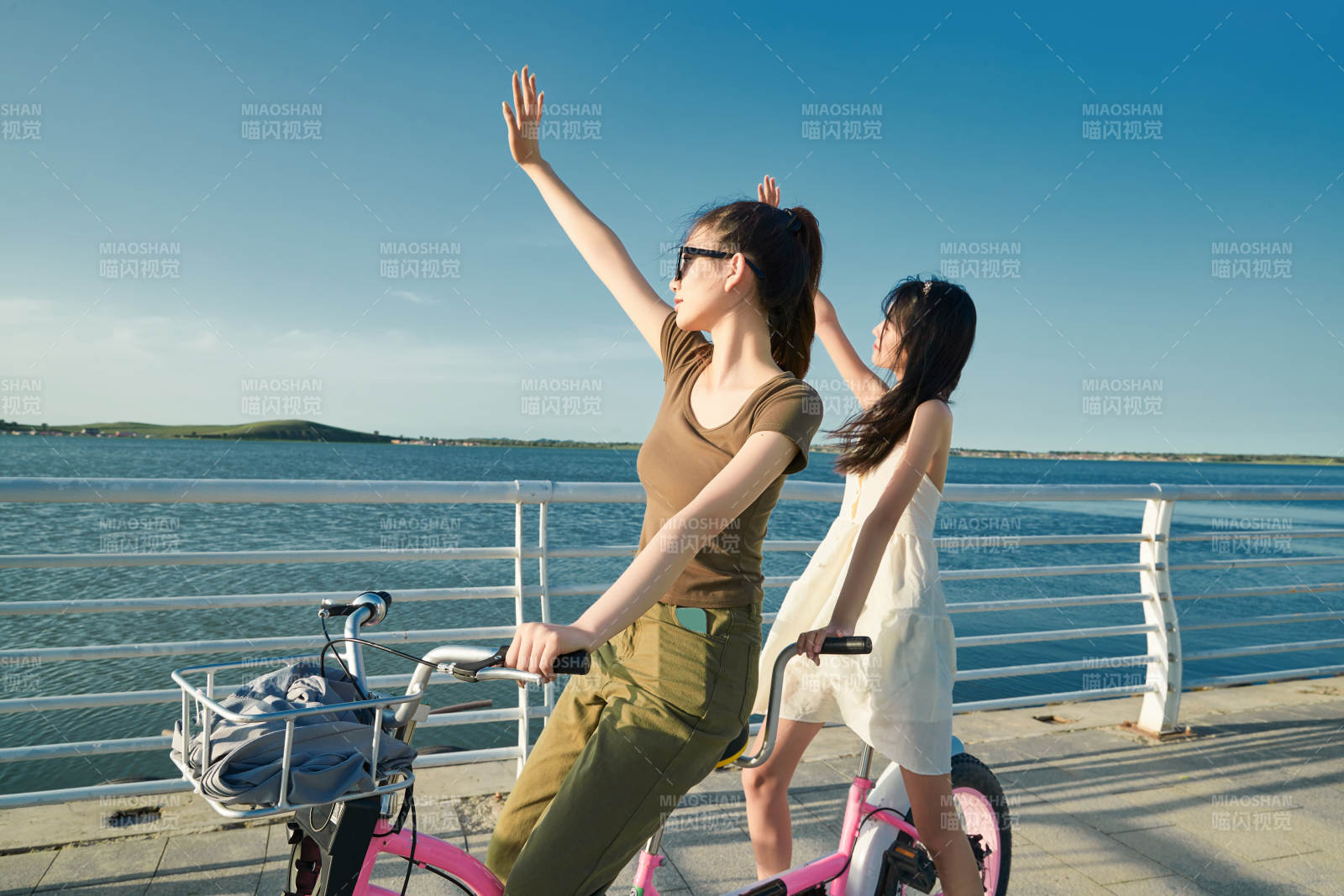 夕阳下湖边码头骑双人脚踏车的闺蜜少女图片