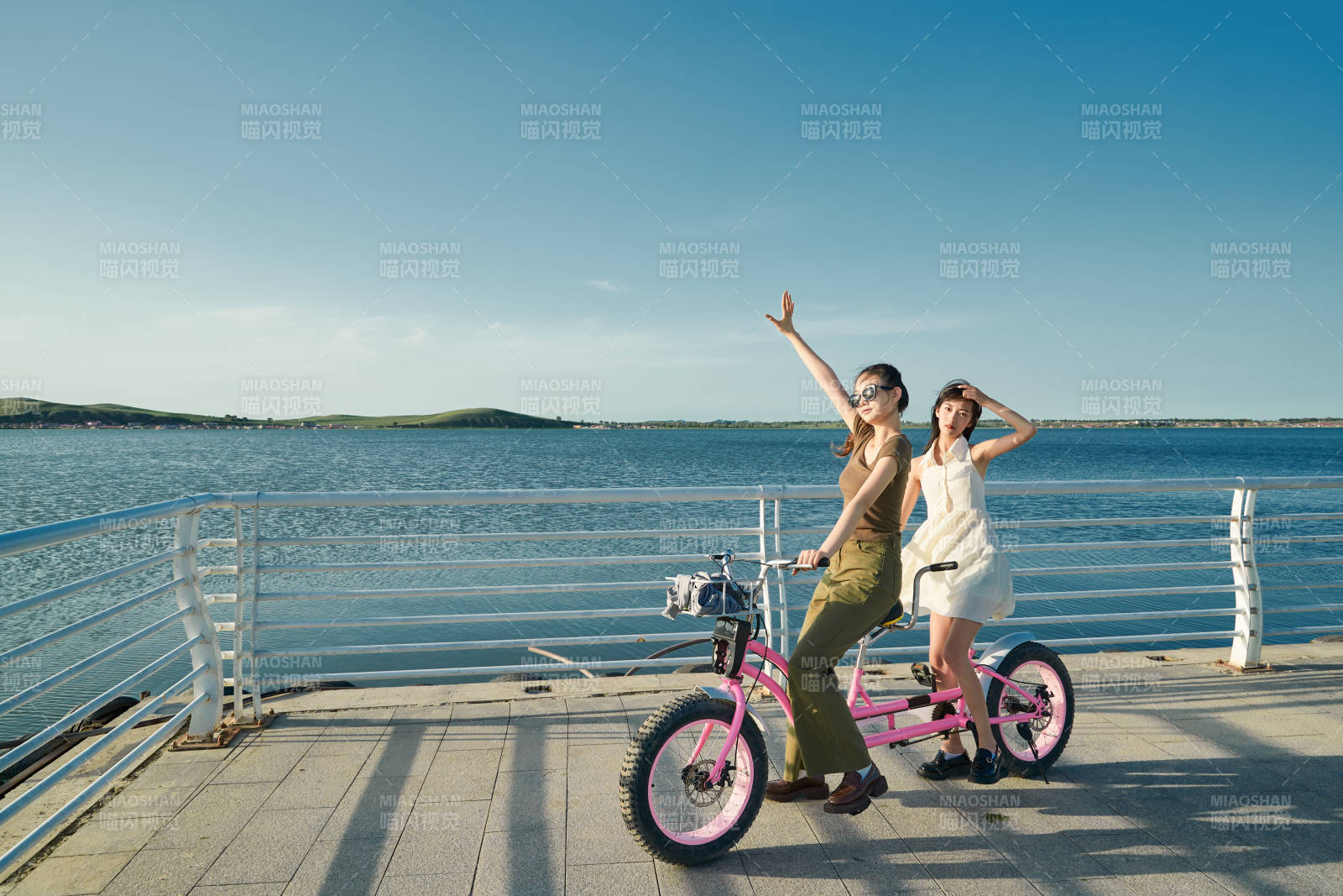 夕阳下湖边码头骑双人脚踏车的闺蜜少女图片