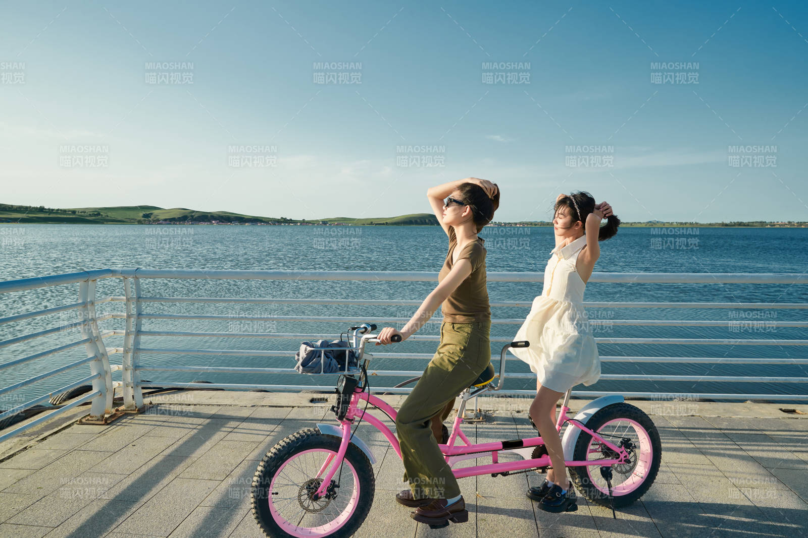 夕阳下湖边码头骑双人脚踏车的闺蜜少女图片
