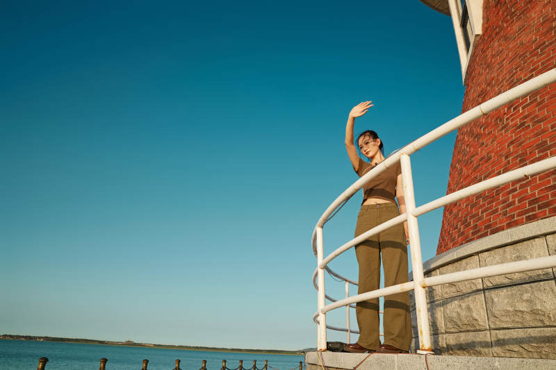 盛夏夕阳晚霞湖边码头灯塔上的少女图片